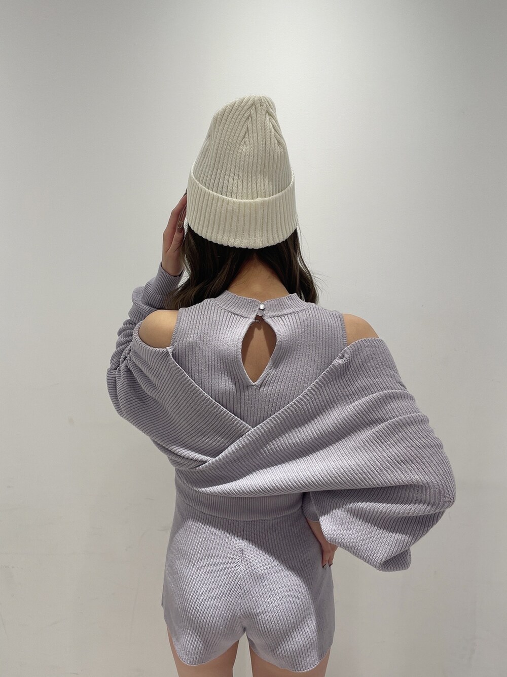 パープル系のサロペット/オーバーオール、ブラック系のブーツ、ホワイト系のニットキャップ/ビーニーを着用したレディースの冬コーディネートの4枚目の写真