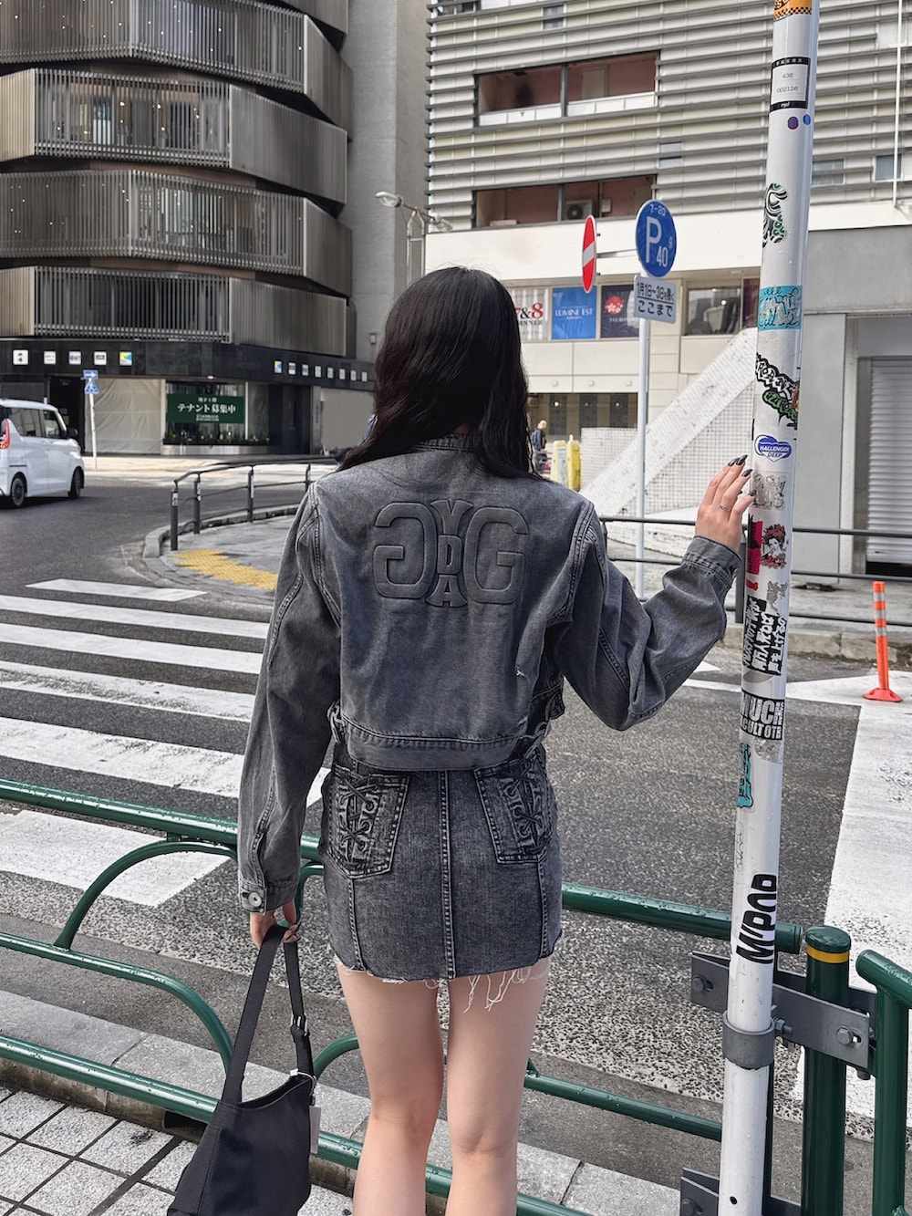 ブラック系のワンピース、ブラック系のデニムジャケット、ブラック系のハンドバッグを着用したレディースの春コーディネートの5枚目の写真