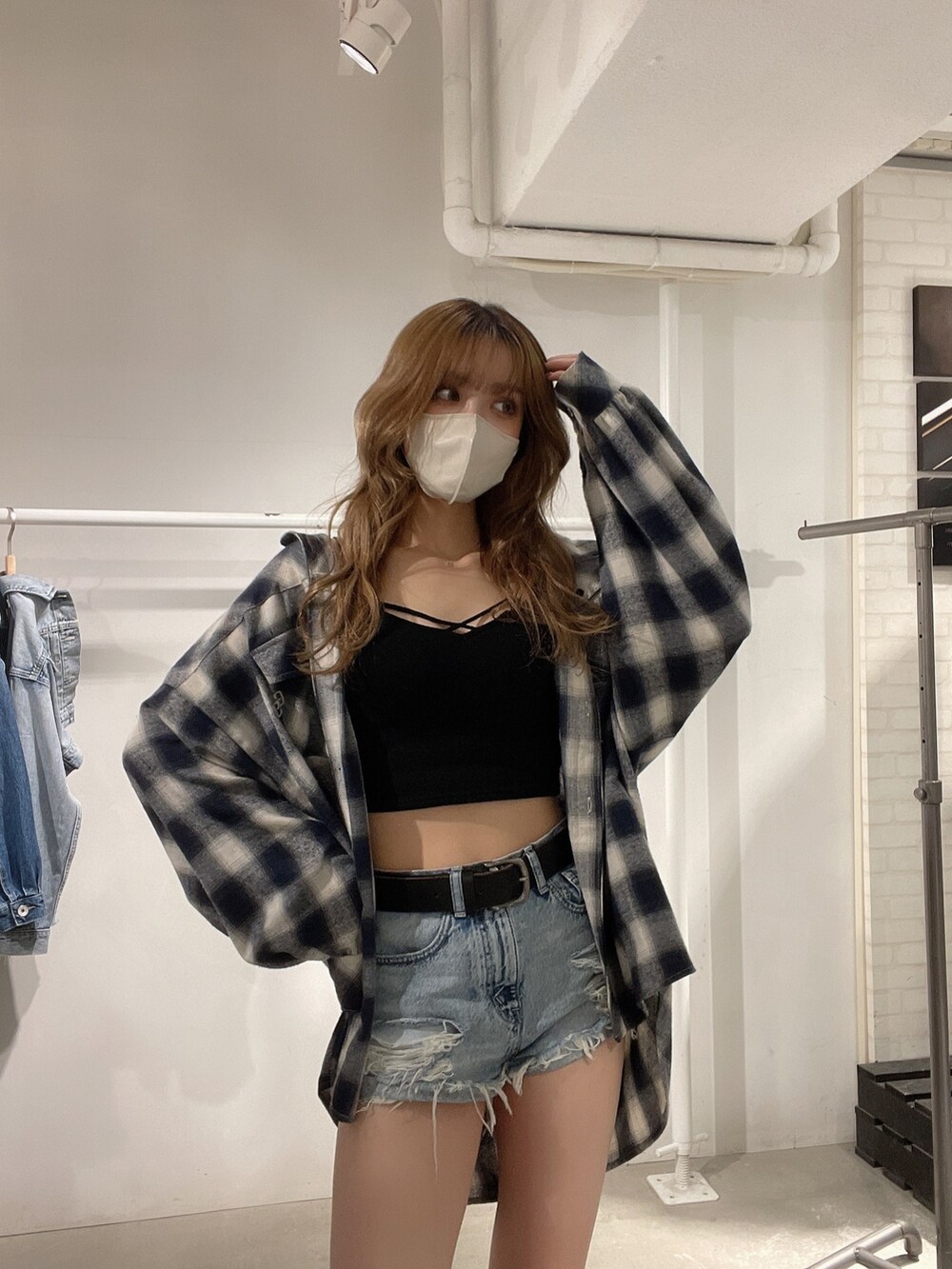 ブラック系のブーツ、ブラック系のキャミソール、ブルー系のデニムパンツを着用したレディースの春コーディネートの4枚目の写真