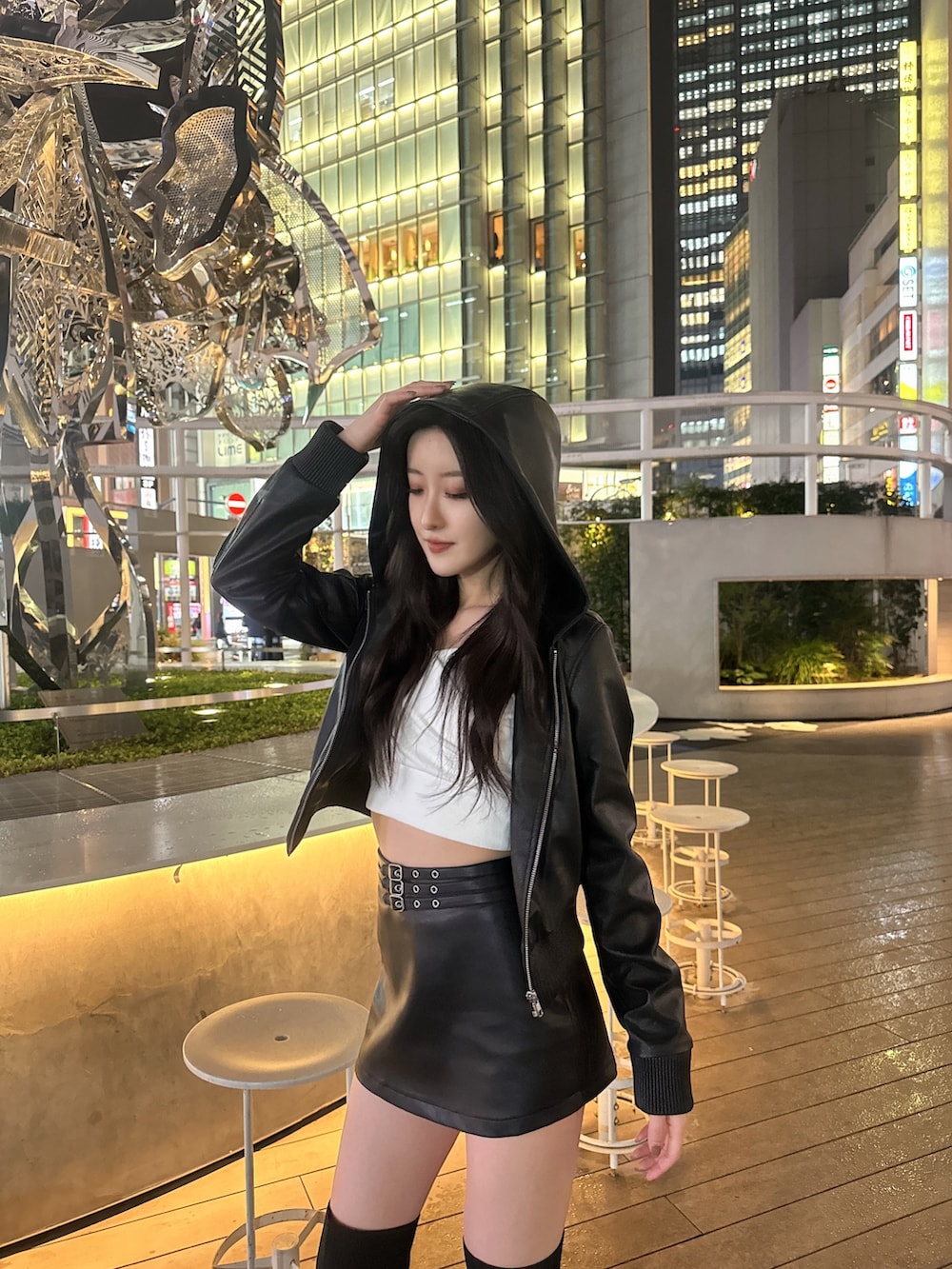 ブラック系のスカート、ブラック系のブルゾン、ホワイト系のTシャツ/カットソーを着用したレディースの春コーディネートの3枚目の写真