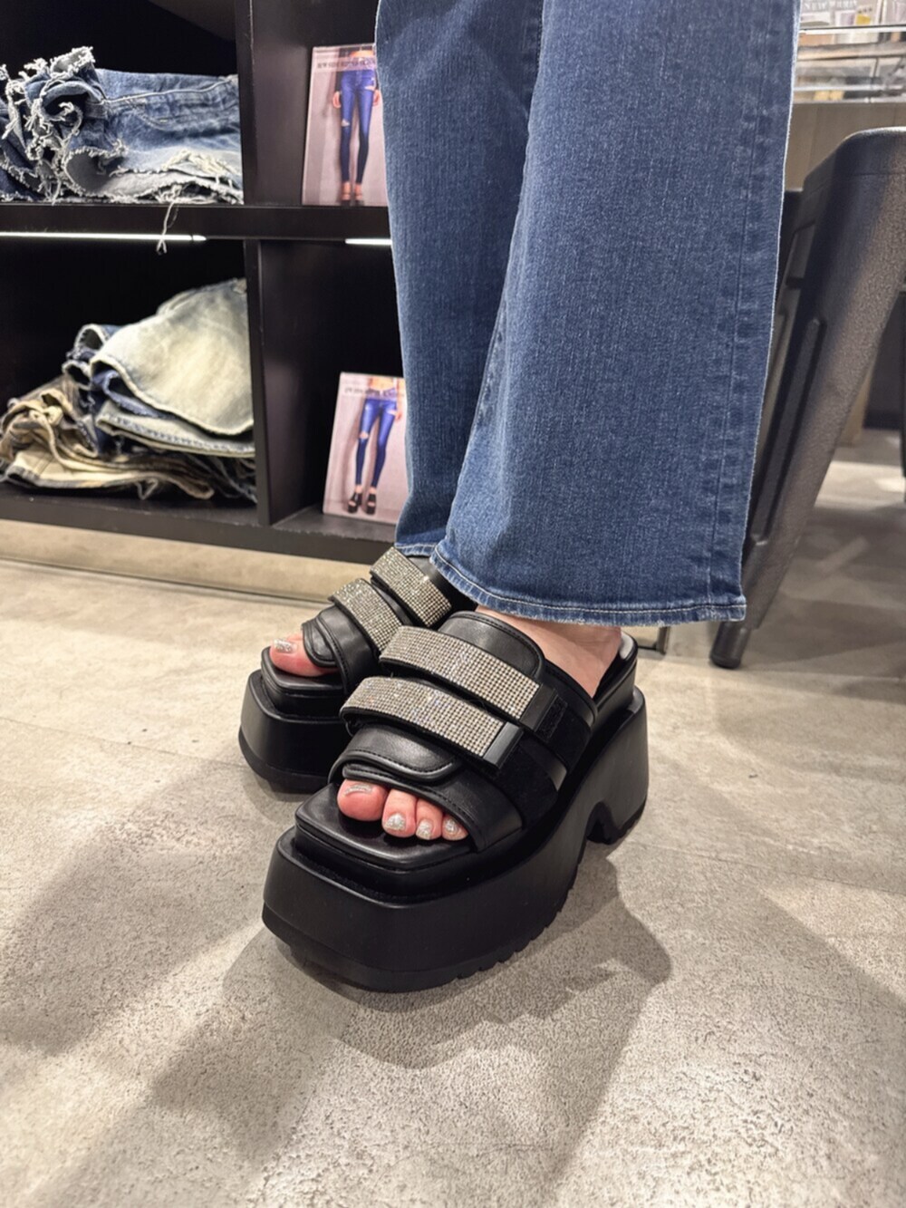 ブラック系のハンドバッグ、ブルー系のデニムパンツ、ブラック系のサンダルを着用したレディースの夏コーディネートの8枚目の写真