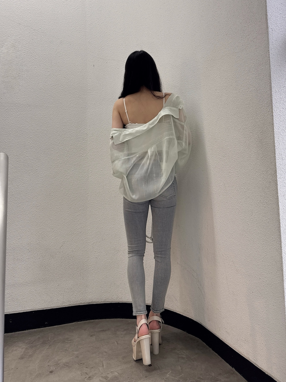 グリーン系のシャツ/ブラウス、ホワイト系のキャミソール、ブルー系のデニムパンツを着用したレディースの春コーディネートの2枚目の写真