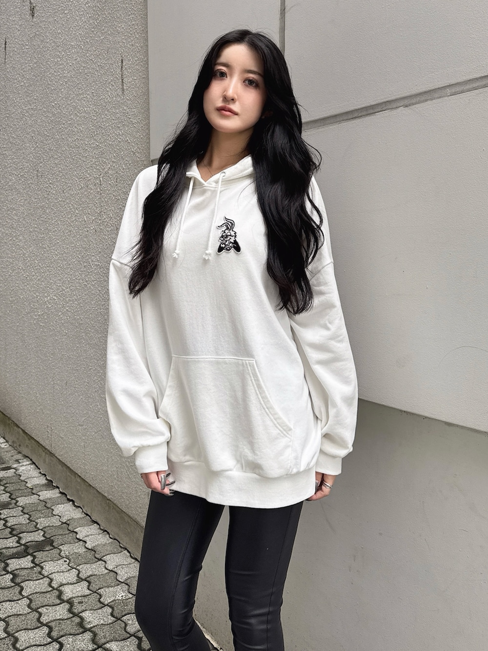 ホワイト系のパーカー、ブラック系のその他パンツ、ブラック系のブーツを着用したレディースの秋コーディネートの4枚目の写真