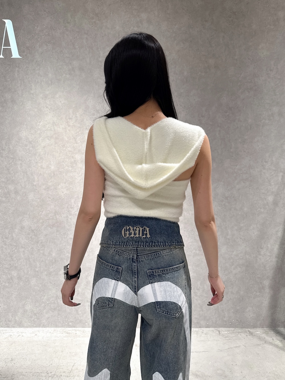 ホワイト系のニット/セーター、ブルー系のデニムパンツ、ホワイト系のパンプスを着用したレディースの秋コーディネートの6枚目の写真