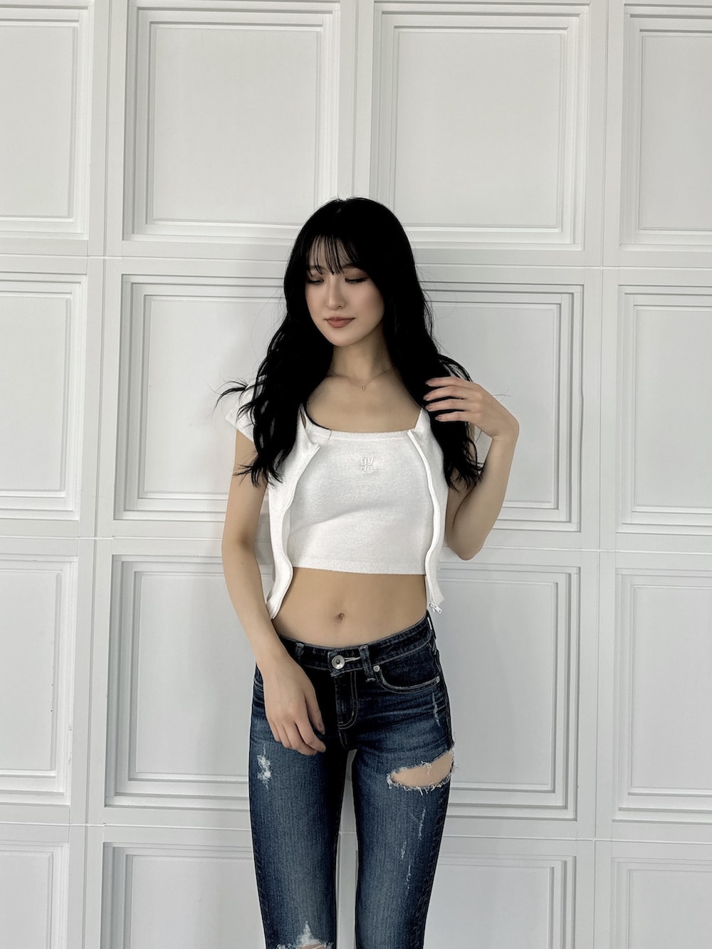 ホワイト系のアンサンブル、ブルー系のデニムパンツ、ホワイト系のサンダルを着用したレディースの夏コーディネートの2枚目の写真