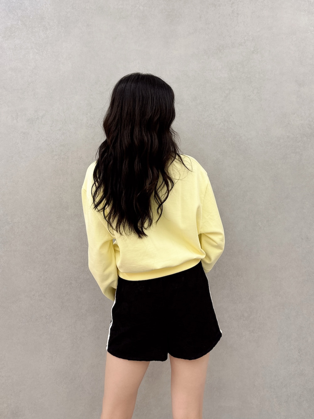 ブラック系のスニーカー、ブラック系のその他パンツ、イエロー系のスウェットを着用したレディースの春コーディネートの3枚目の写真