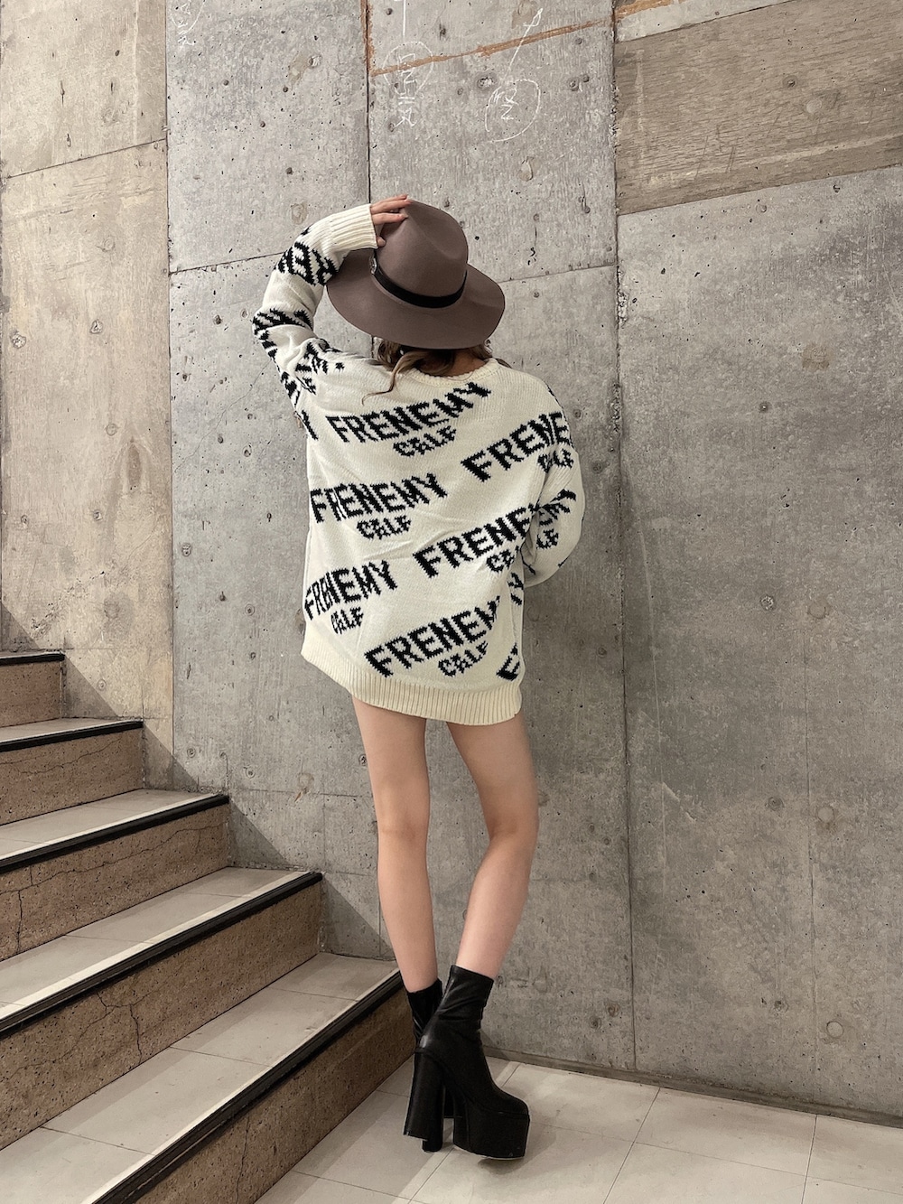 ホワイト系のニット/セーター、ブラック系のブーツ、ブラック系のデニムパンツを着用したレディースの秋コーディネートの2枚目の写真