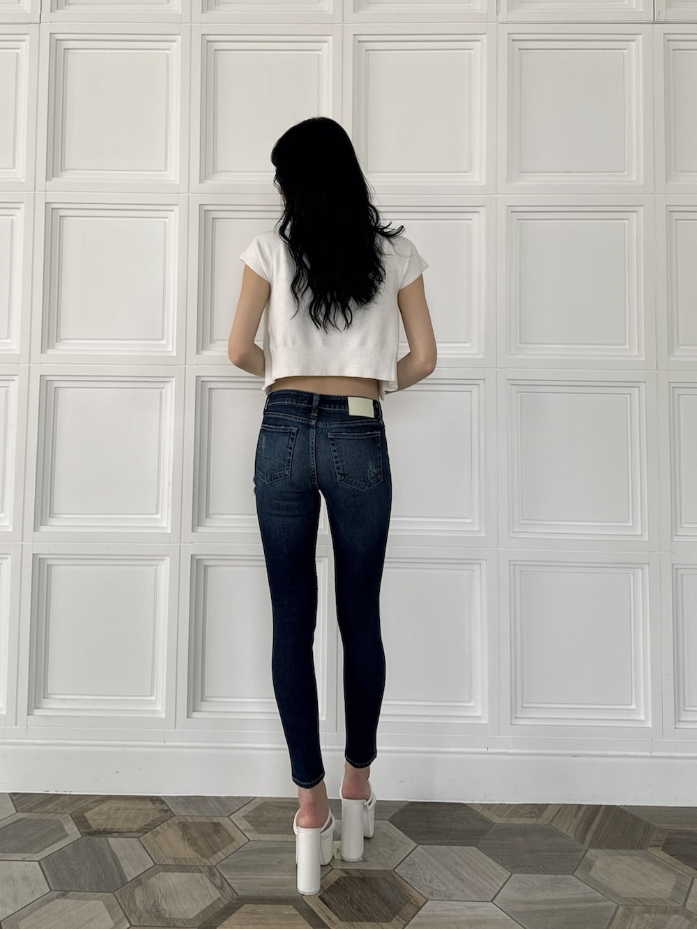 ホワイト系のアンサンブル、ブルー系のデニムパンツ、ホワイト系のサンダルを着用したレディースの夏コーディネートの3枚目の写真