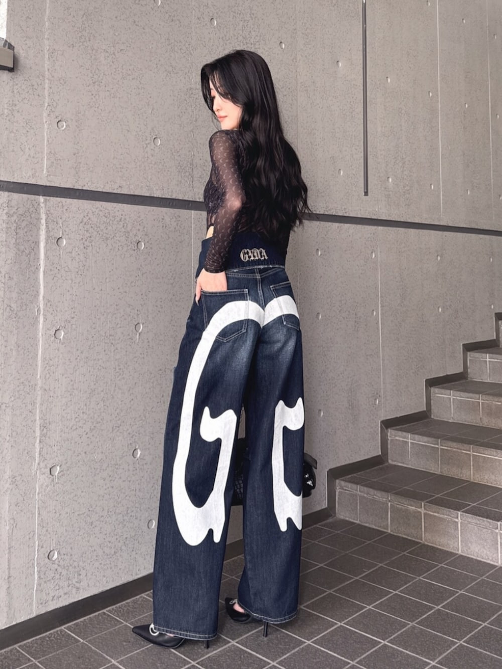 ブラック系のTシャツ/カットソー、ブルー系のデニムパンツ、ブラック系のパンプスを着用したレディースの夏コーディネートの3枚目の写真