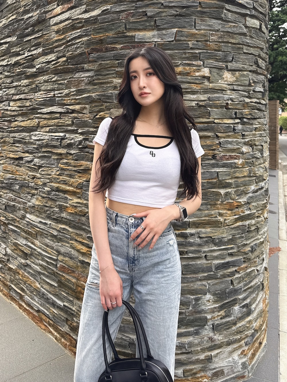 ホワイト系のTシャツ/カットソー、ブラック系のボストンバッグ、ブルー系のデニムパンツを着用したレディースの夏コーディネートの4枚目の写真