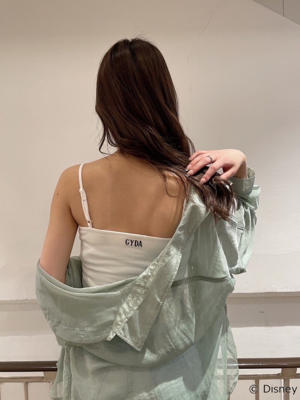グリーン系のシャツ/ブラウス、ホワイト系のキャミソール、ブルー系のデニムパンツを着用したレディースの春コーディネートの3枚目の写真