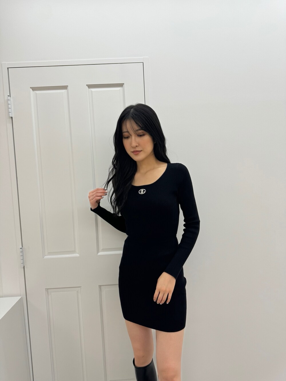 ブラック系のワンピース、ブラック系のブーツを着用したレディースの秋コーディネートの2枚目の写真