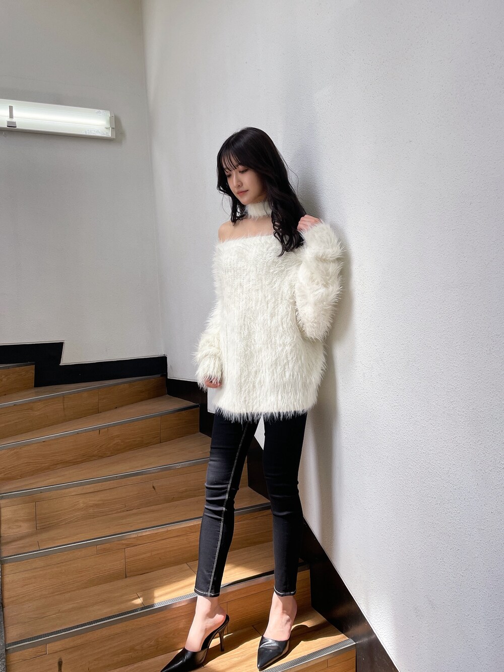 ホワイト系のニット/セーター、ブラック系のデニムパンツ、ブラック系のパンプスを着用したレディースの秋コーディネートの3枚目の写真