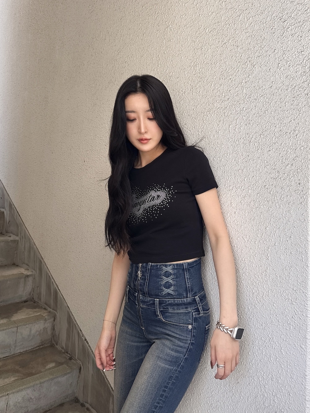 ブラック系のTシャツ/カットソー、ブルー系のデニムパンツ、ブラック系のサンダルを着用したレディースの春コーディネートの2枚目の写真