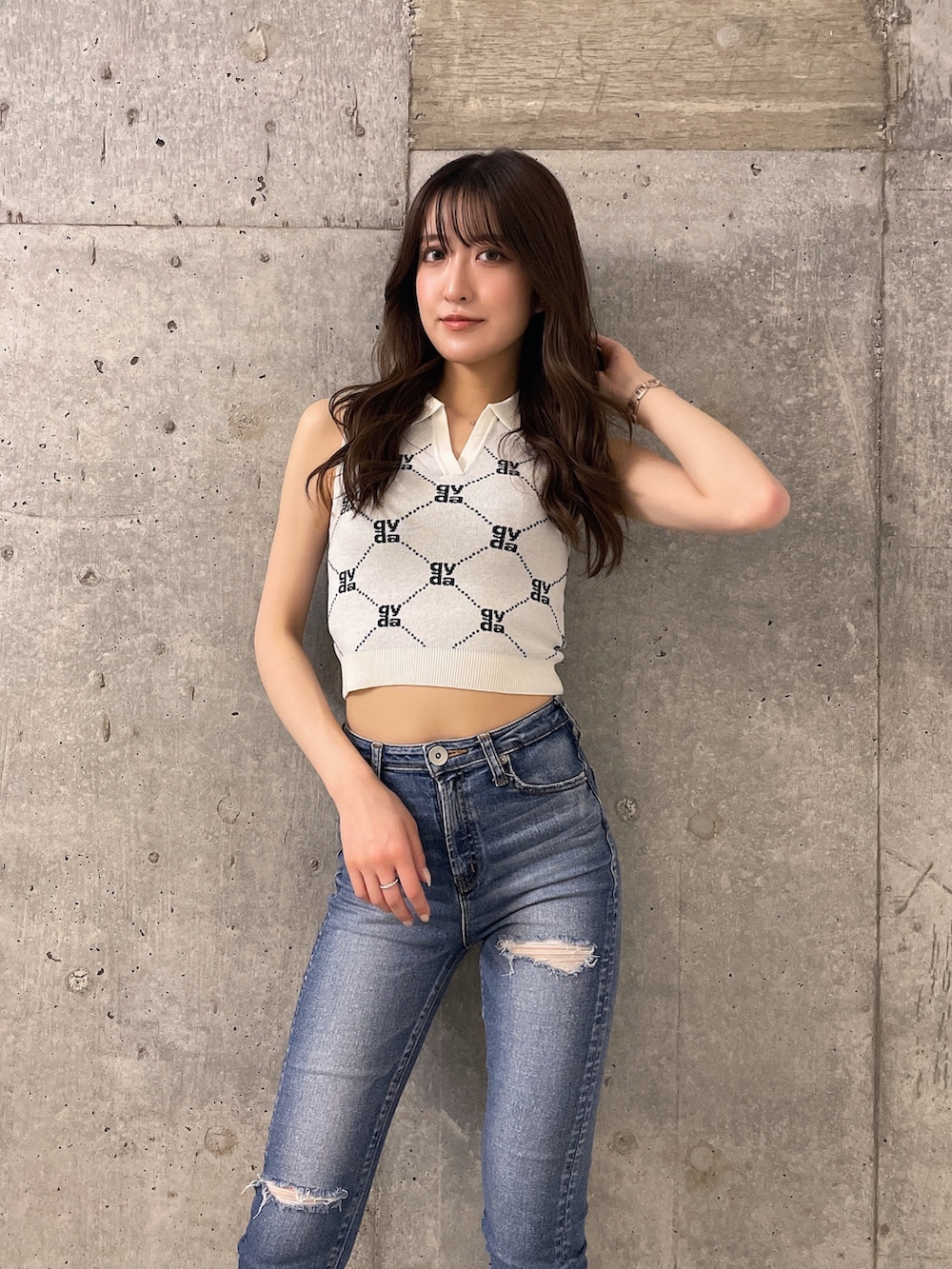 ホワイト系のニット/セーター、ブルー系のデニムパンツ、ホワイト系のサンダルを着用したレディースの春コーディネートの2枚目の写真