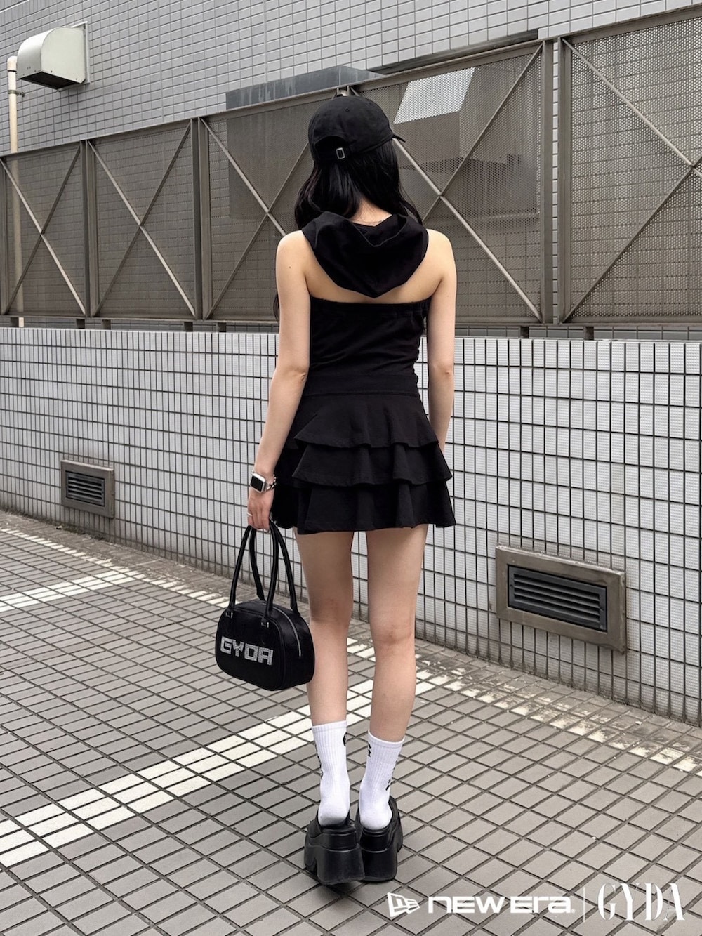 ブラック系のワンピース、ブラック系のボストンバッグ、ブラック系のキャップを着用したレディースの夏コーディネートの3枚目の写真