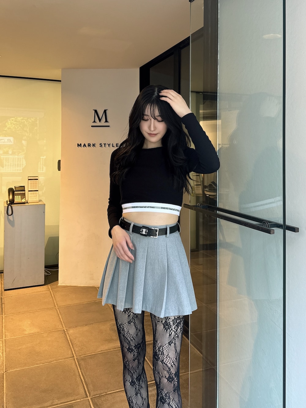 ブラック系のTシャツ/カットソー、グレー系のスカート、ブラック系のブーツを着用したレディースの夏コーディネートの3枚目の写真