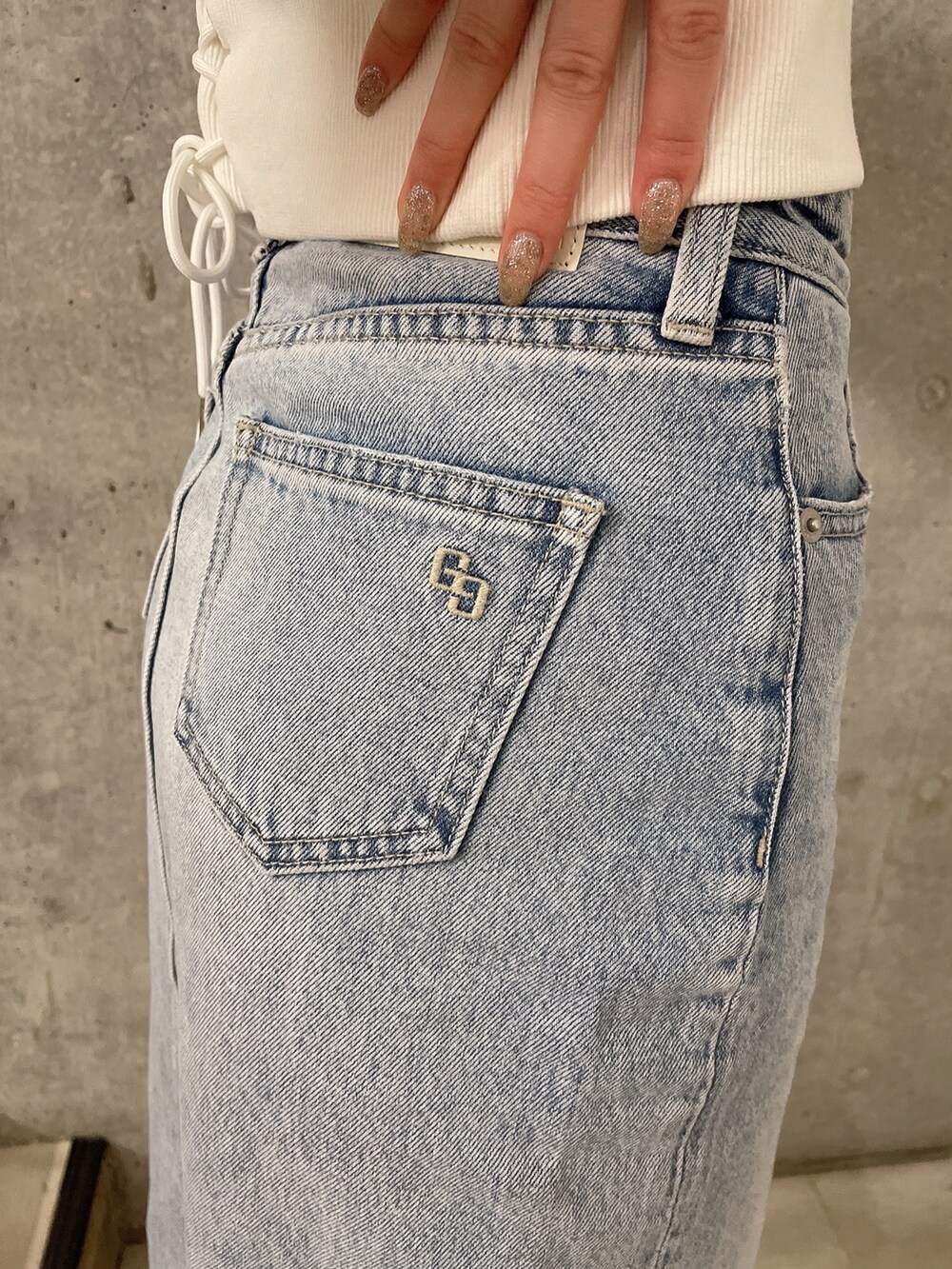 ホワイト系のパーカー、ブルー系のデニムスカート、ホワイト系のパンプスを着用したレディースの冬コーディネートの8枚目の写真