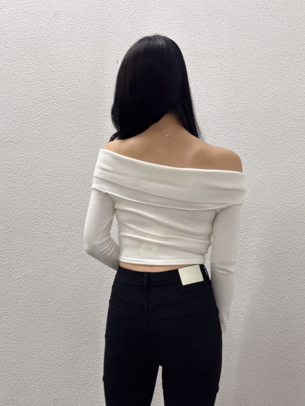 ブラック系のブーツ、ブラック系のデニムパンツ、ホワイト系のニット/セーターを着用したレディースの秋コーディネートの6枚目の写真