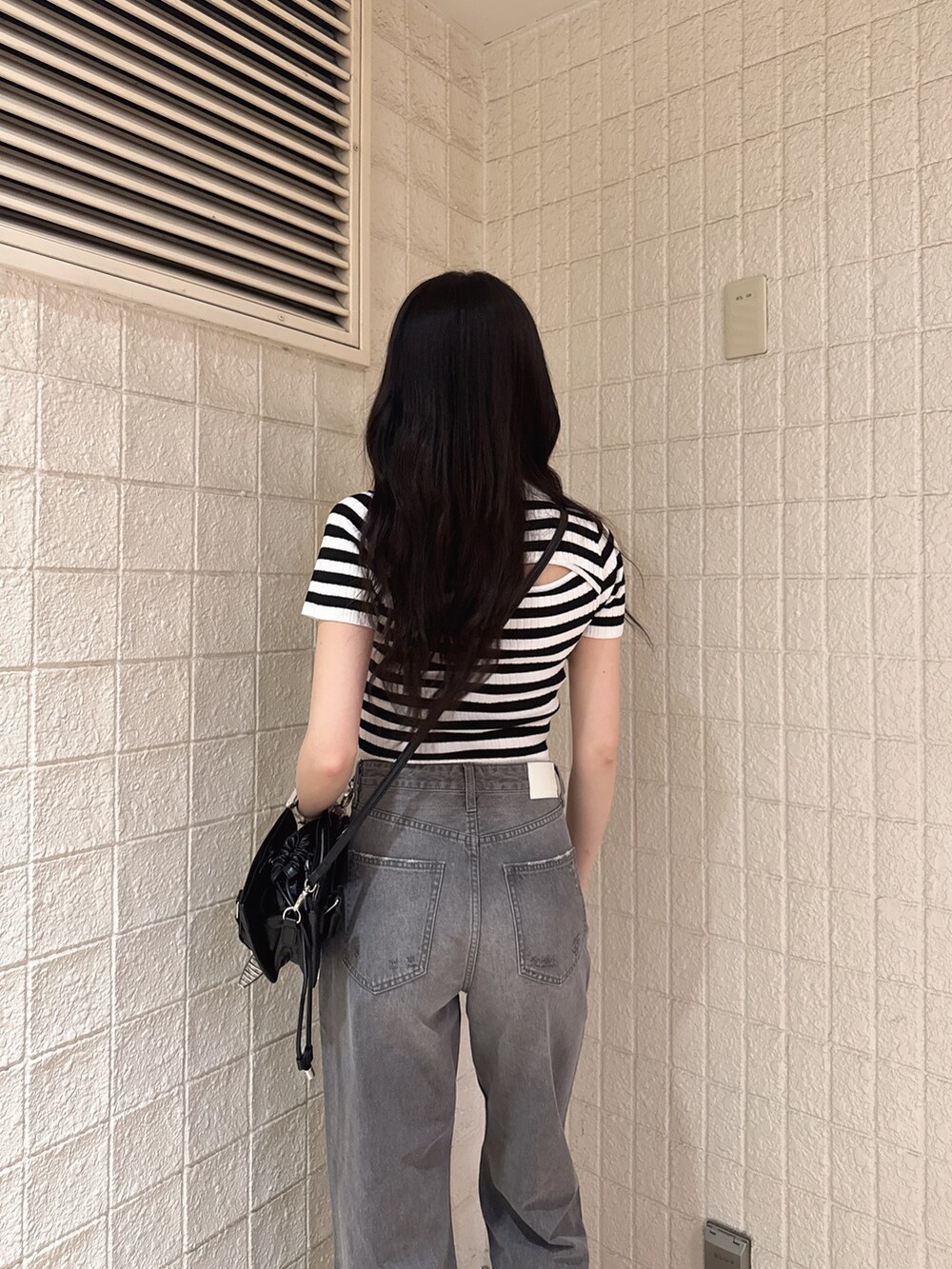 その他のニット/セーター、グレー系のデニムパンツ、ブラック系のサンダルを着用したレディースの春コーディネートの4枚目の写真