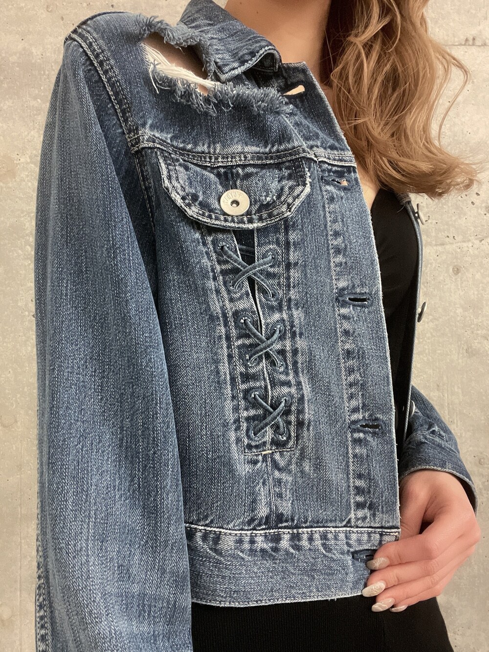 ブルー系のデニムジャケット、ブラック系のつなぎ/オールインワン、ホワイト系のサンダルを着用したレディースの春コーディネートの6枚目の写真