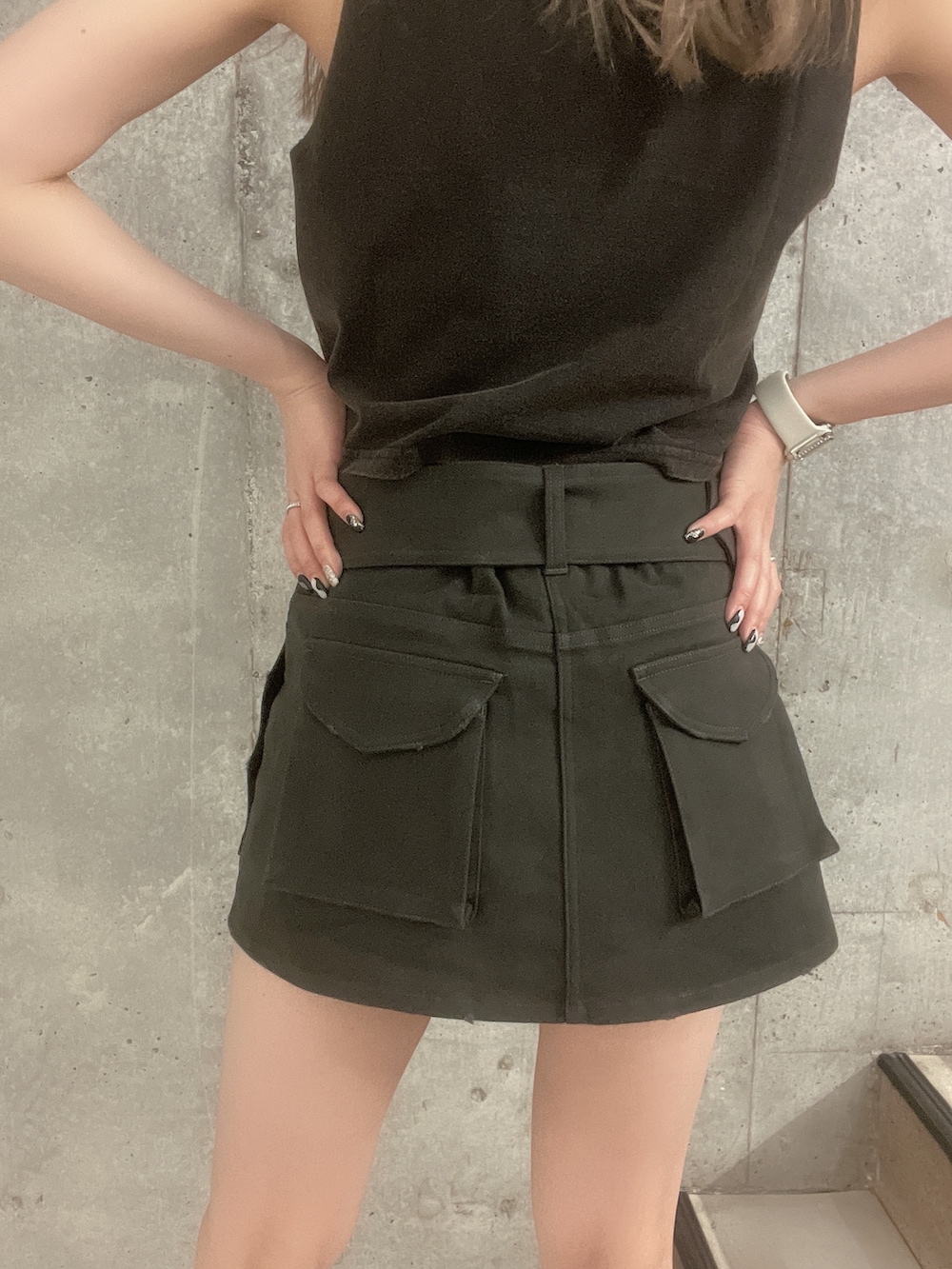 ブラック系のタンクトップ、グレー系のスカート、ブラック系のサンダルを着用したレディースの夏コーディネートの5枚目の写真