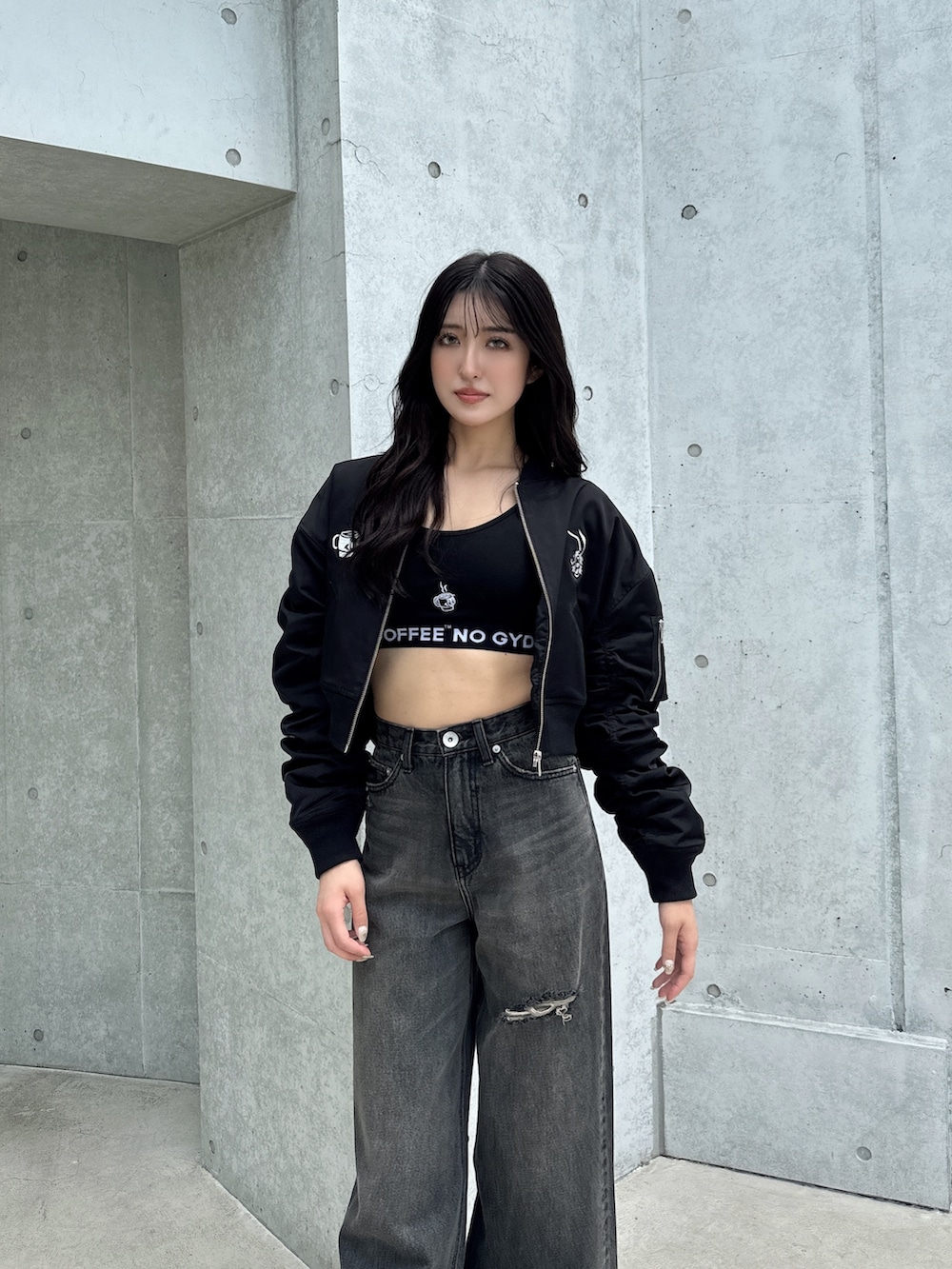 ブラック系のブルゾン、ブラック系のキャミソール、ブラック系のデニムパンツを着用したレディースの秋コーディネートの2枚目の写真