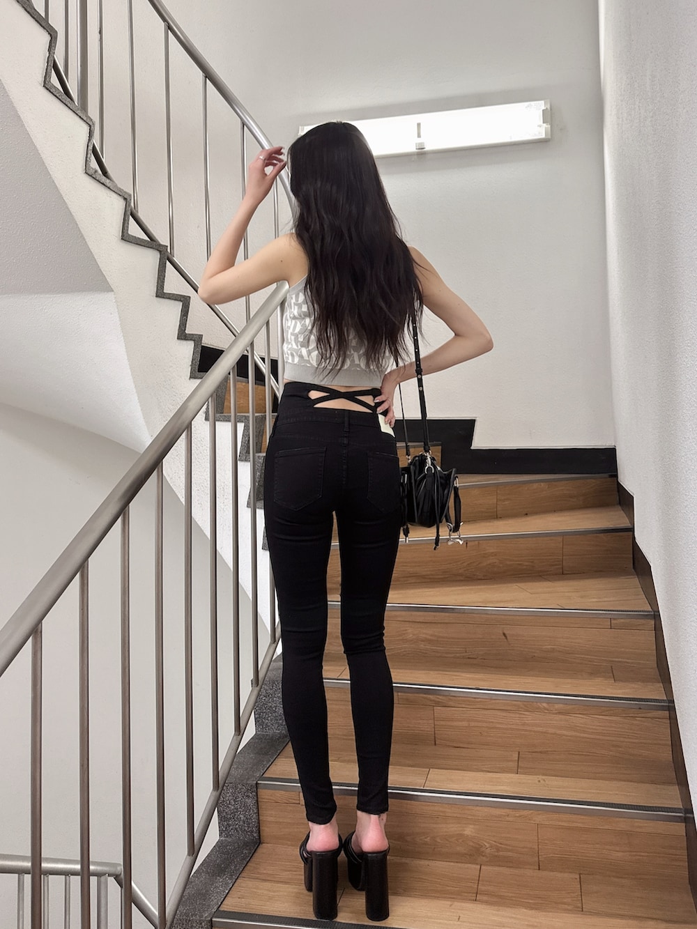 グレー系のニット/セーター、ブラック系のデニムパンツ、ブラック系のサンダルを着用したレディースの夏コーディネートの3枚目の写真