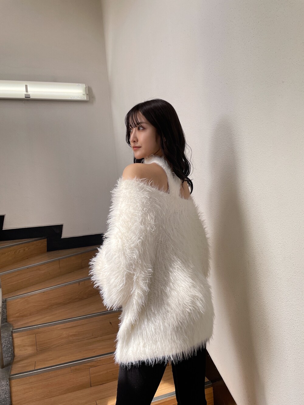 ホワイト系のニット/セーター、ブラック系のデニムパンツ、ブラック系のパンプスを着用したレディースの秋コーディネートの2枚目の写真