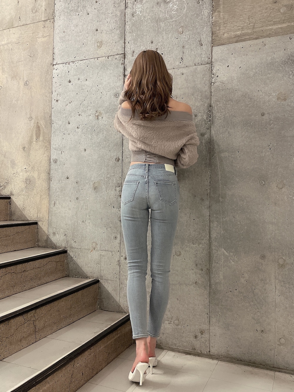 ベージュ系のニット/セーター、ブルー系のデニムパンツ、ホワイト系のパンプスを着用したレディースの秋コーディネートの4枚目の写真