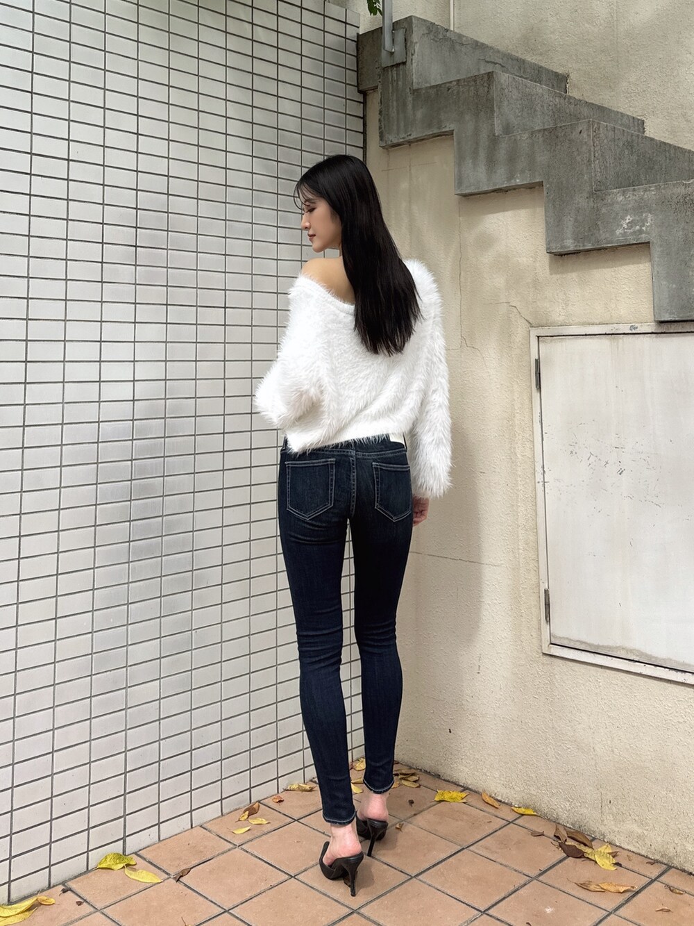 ホワイト系のニット/セーター、ブルー系のデニムパンツ、ブラック系のパンプスを着用したレディースの冬コーディネートの2枚目の写真