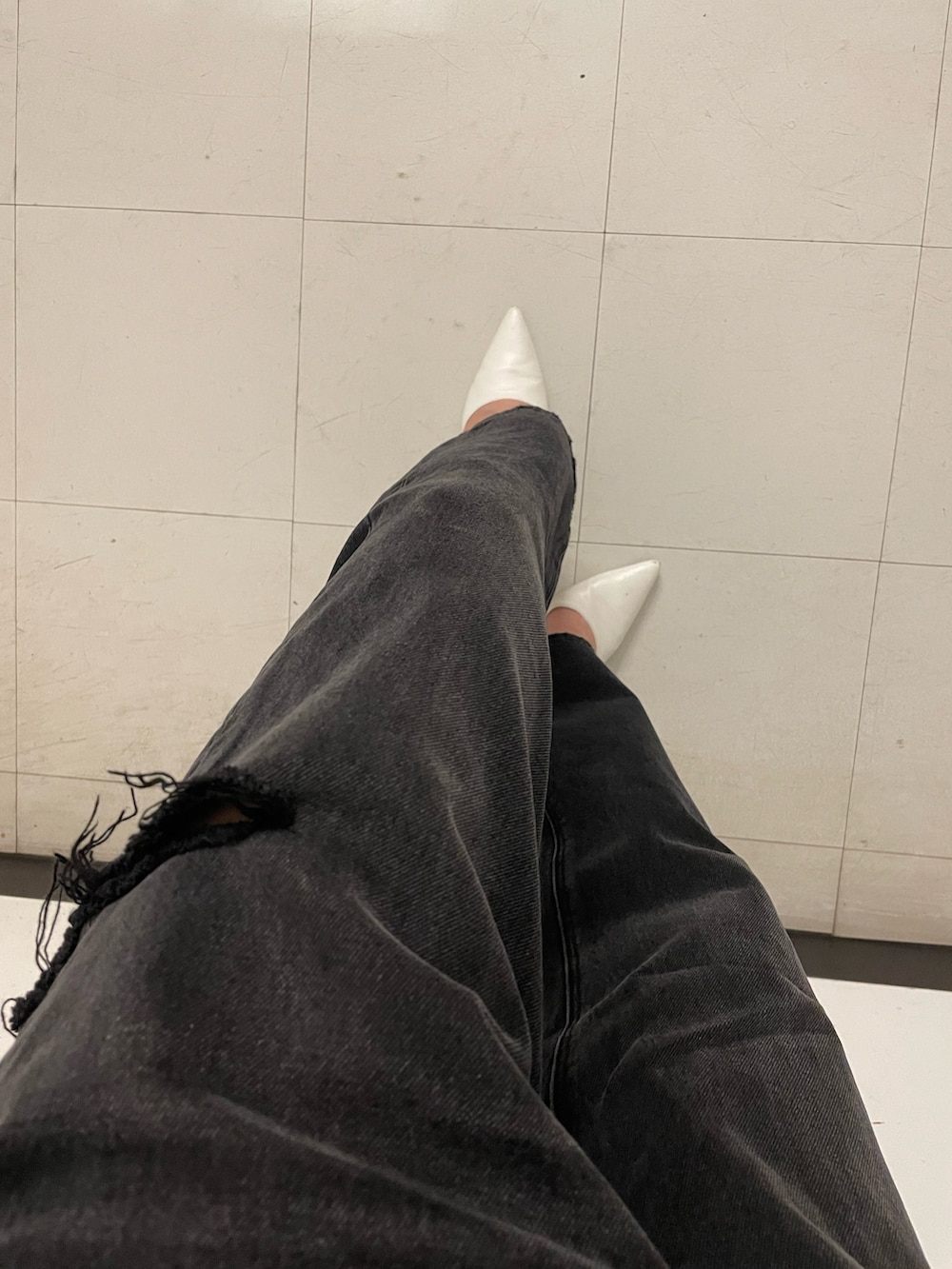 ブラック系のデニムパンツ、ホワイト系のパンプス、ホワイト系のニット/セーターを着用したレディースの夏コーディネートの5枚目の写真