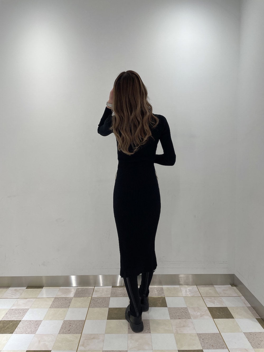 ブラック系のワンピース、ブラック系のブーツ、ホワイト系のボストンバッグを着用したレディースの秋コーディネートの3枚目の写真