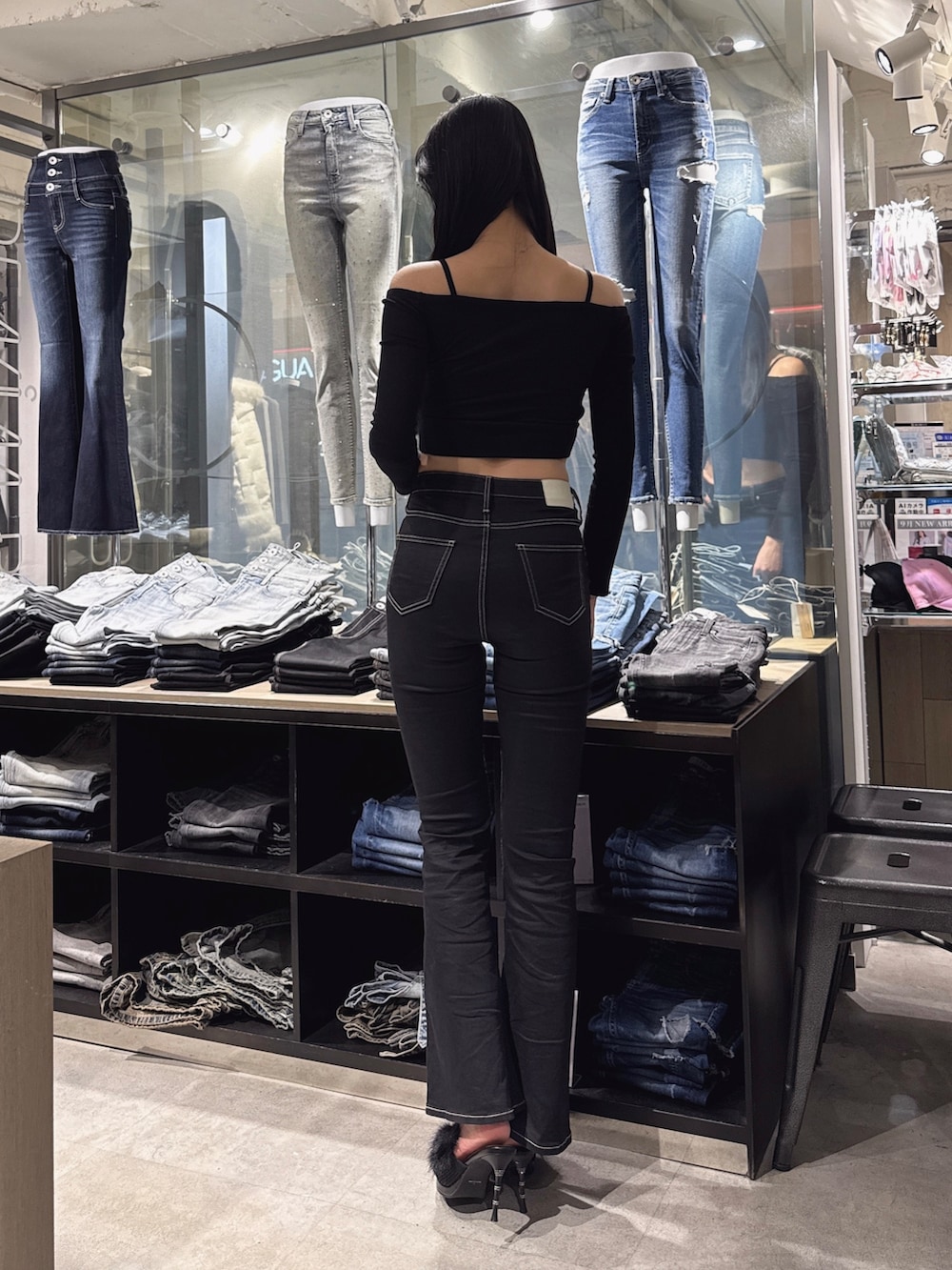 ブラック系のTシャツ/カットソー、ブラック系のデニムパンツ、ブラック系のパンプスを着用したレディースの秋コーディネートの3枚目の写真