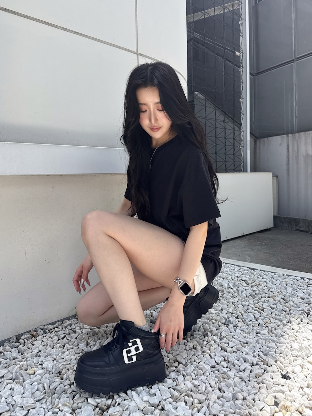 ブラック系のTシャツ/カットソー、ホワイト系のデニムパンツ、ブラック系のスニーカーを着用したレディースの夏コーディネートの3枚目の写真