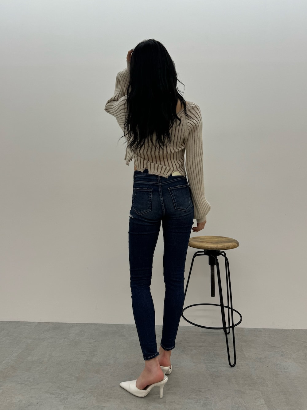 ベージュ系のニット/セーター、ブルー系のデニムパンツ、ホワイト系のパンプスを着用したレディースの冬コーディネートの3枚目の写真