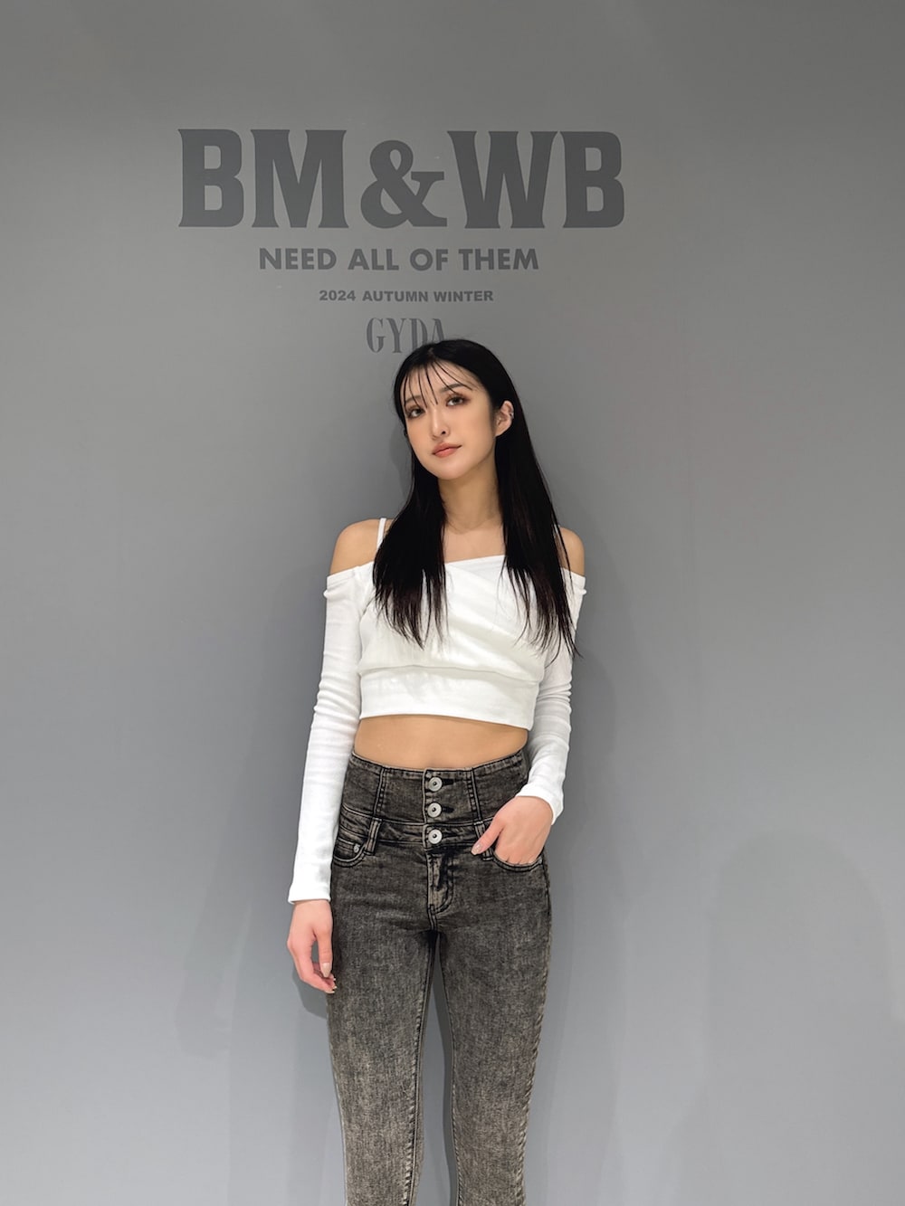 ホワイト系のTシャツ/カットソー、ブラック系のデニムパンツ、ブラック系のブーツを着用したレディースの秋コーディネートの3枚目の写真