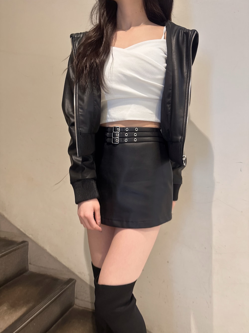 ブラック系のスカート、ブラック系のブルゾン、ホワイト系のTシャツ/カットソーを着用したレディースの春コーディネートの5枚目の写真