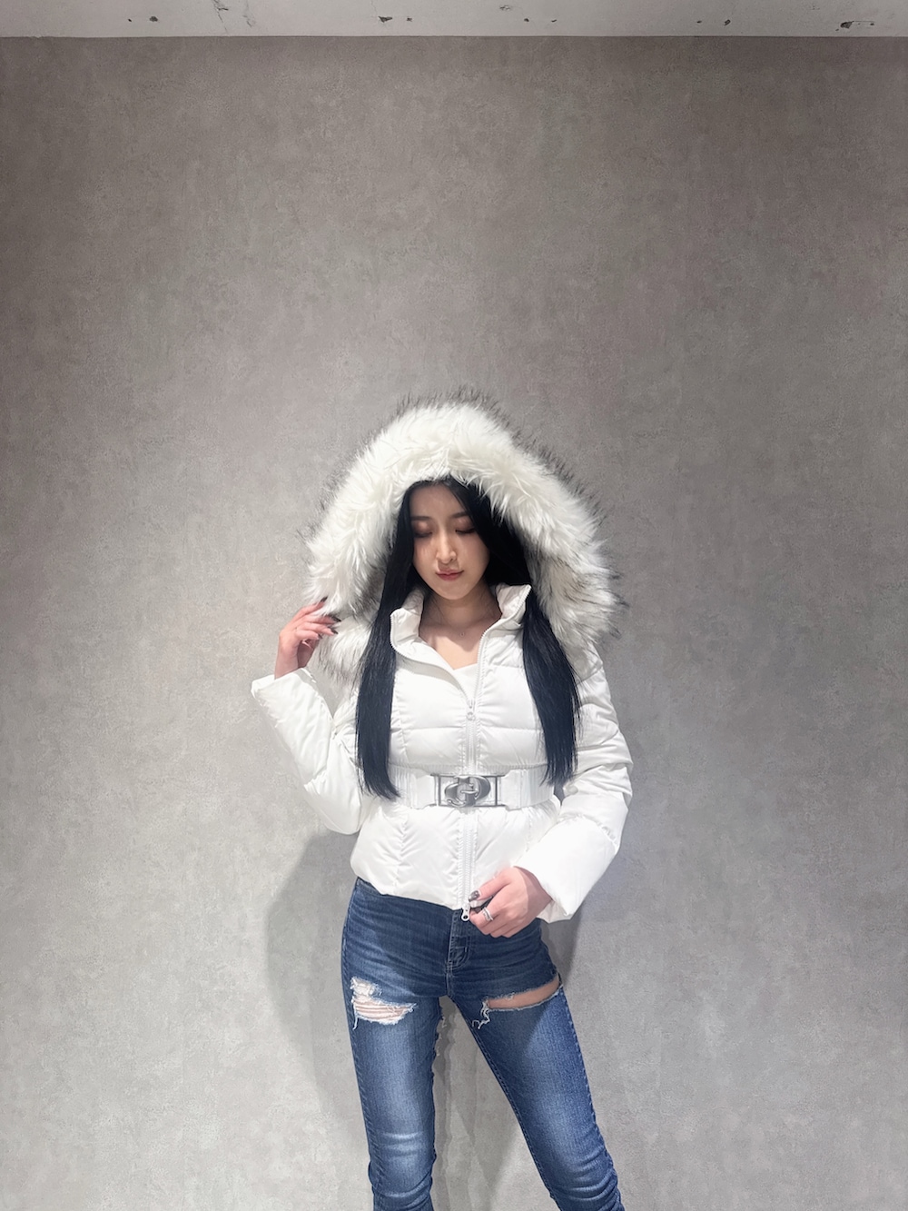 ホワイト系のダウンジャケット/コート、ブルー系のデニムパンツ、ブラック系のブーツを着用したレディースの秋コーディネートの2枚目の写真