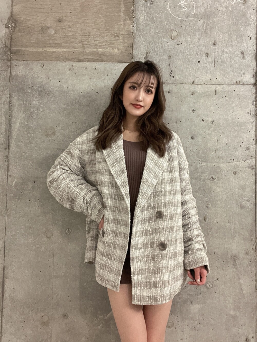 ベージュ系のワンピース、ブラック系のブーツ、ベージュ系のチェスターコートを着用したレディースの冬コーディネートの2枚目の写真