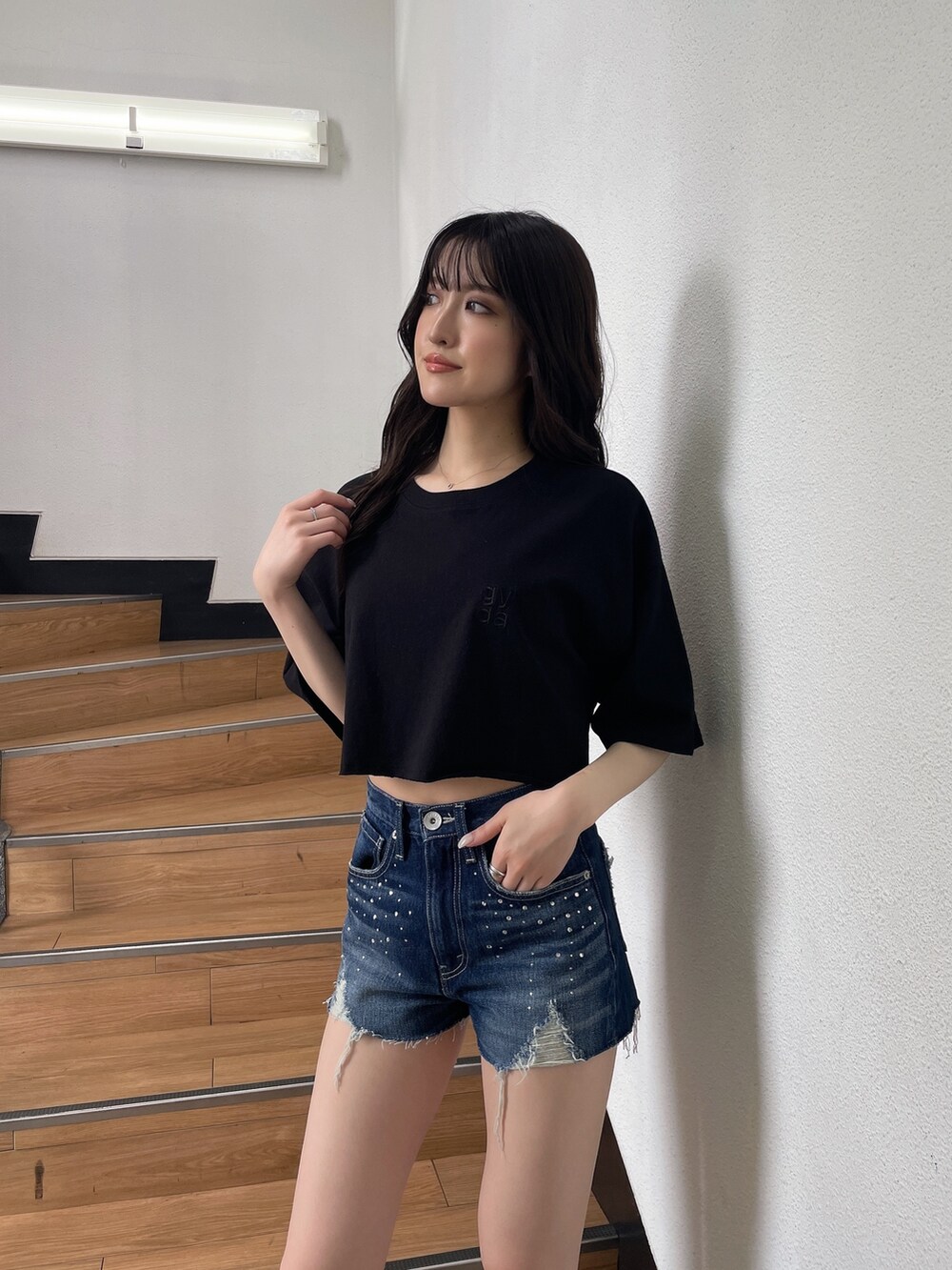 ブラック系のTシャツ/カットソー、ブルー系のデニムパンツ、ブラック系のサンダルを着用したレディースの春コーディネートの2枚目の写真