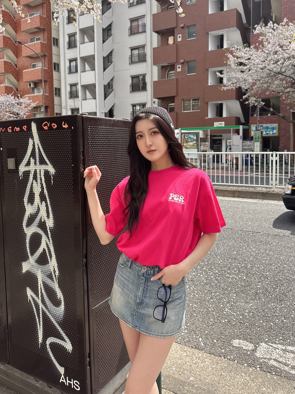 ピンク系のTシャツ/カットソー、ブルー系のデニムスカート、ブラック系のスニーカーを着用したレディースの春コーディネートの5枚目の写真