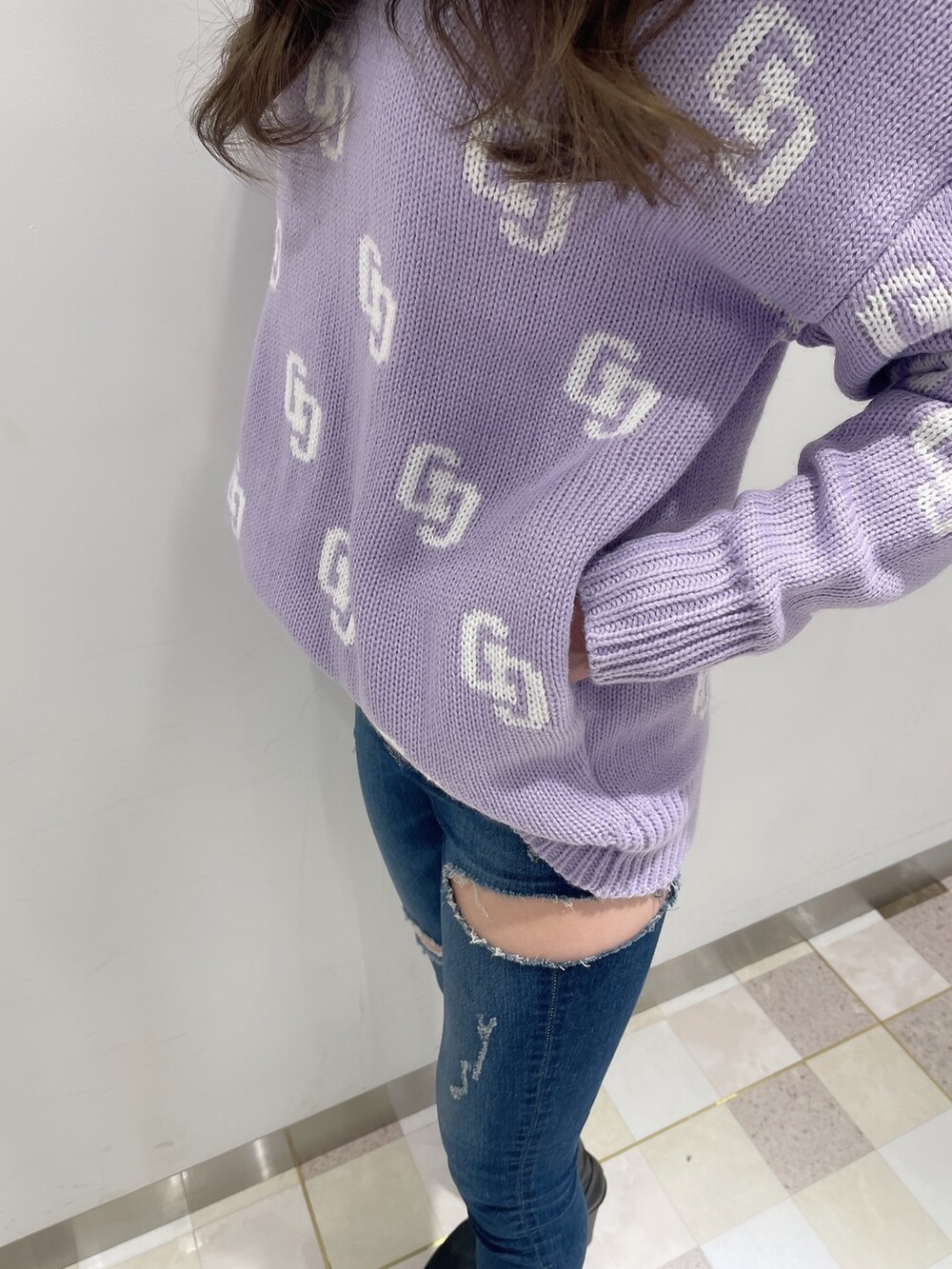 パープル系のニット/セーター、ブルー系のデニムパンツ、ブラック系のブーツを着用したレディースの冬コーディネートの6枚目の写真