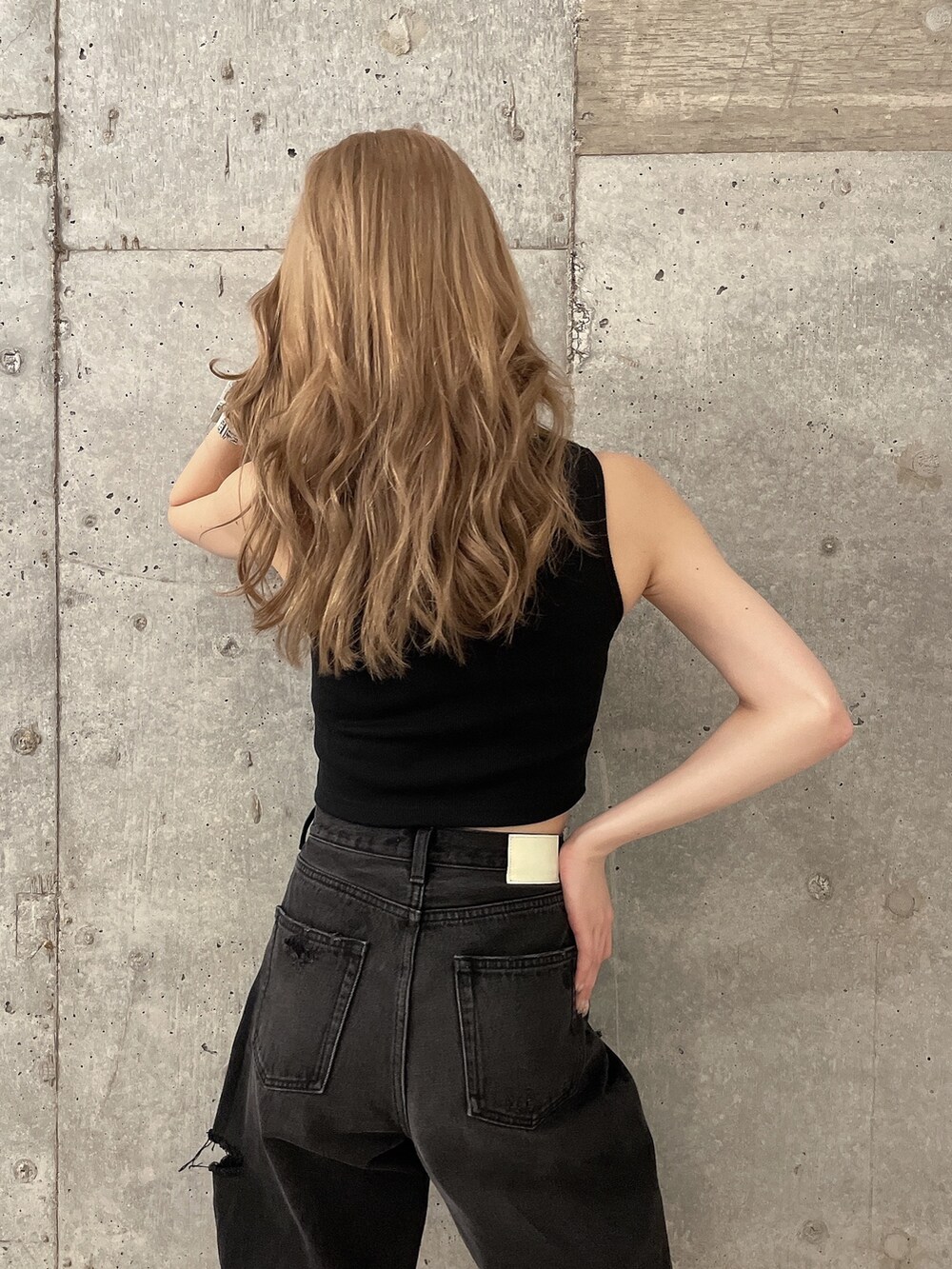 ブラック系のデニムパンツ、ブラック系のタンクトップ、ブラック系のパンプスを着用したレディースの夏コーディネートの5枚目の写真