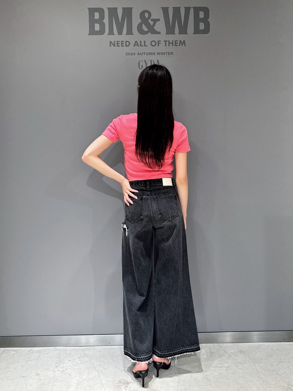 ピンク系のTシャツ/カットソー、ブラック系のデニムパンツ、ブラック系のパンプスを着用したレディースの夏コーディネートの2枚目の写真