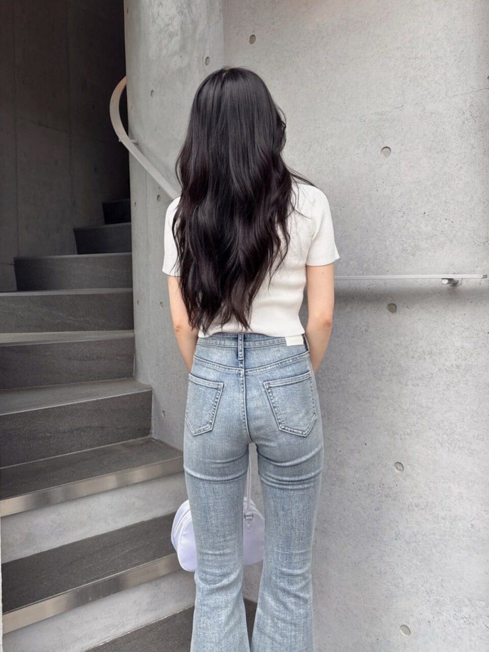 ホワイト系のニット/セーター、ブルー系のデニムパンツ、ホワイト系のボストンバッグを着用したレディースの夏コーディネートの6枚目の写真