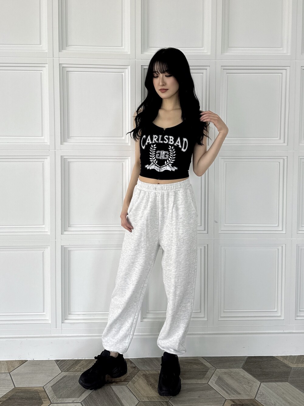 ブラック系のキャミソール、グレー系のスウェットパンツ、ブラック系のスニーカーを着用したレディースの夏コーディネートの3枚目の写真