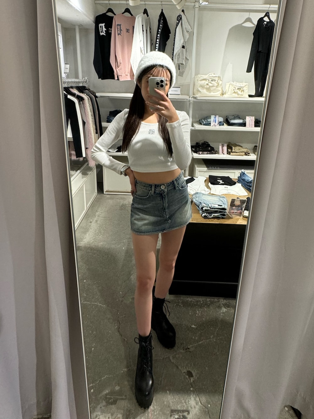 ホワイト系のTシャツ/カットソー、ブルー系のデニムスカート、ブラック系のブーツを着用したレディースの夏コーディネートの3枚目の写真