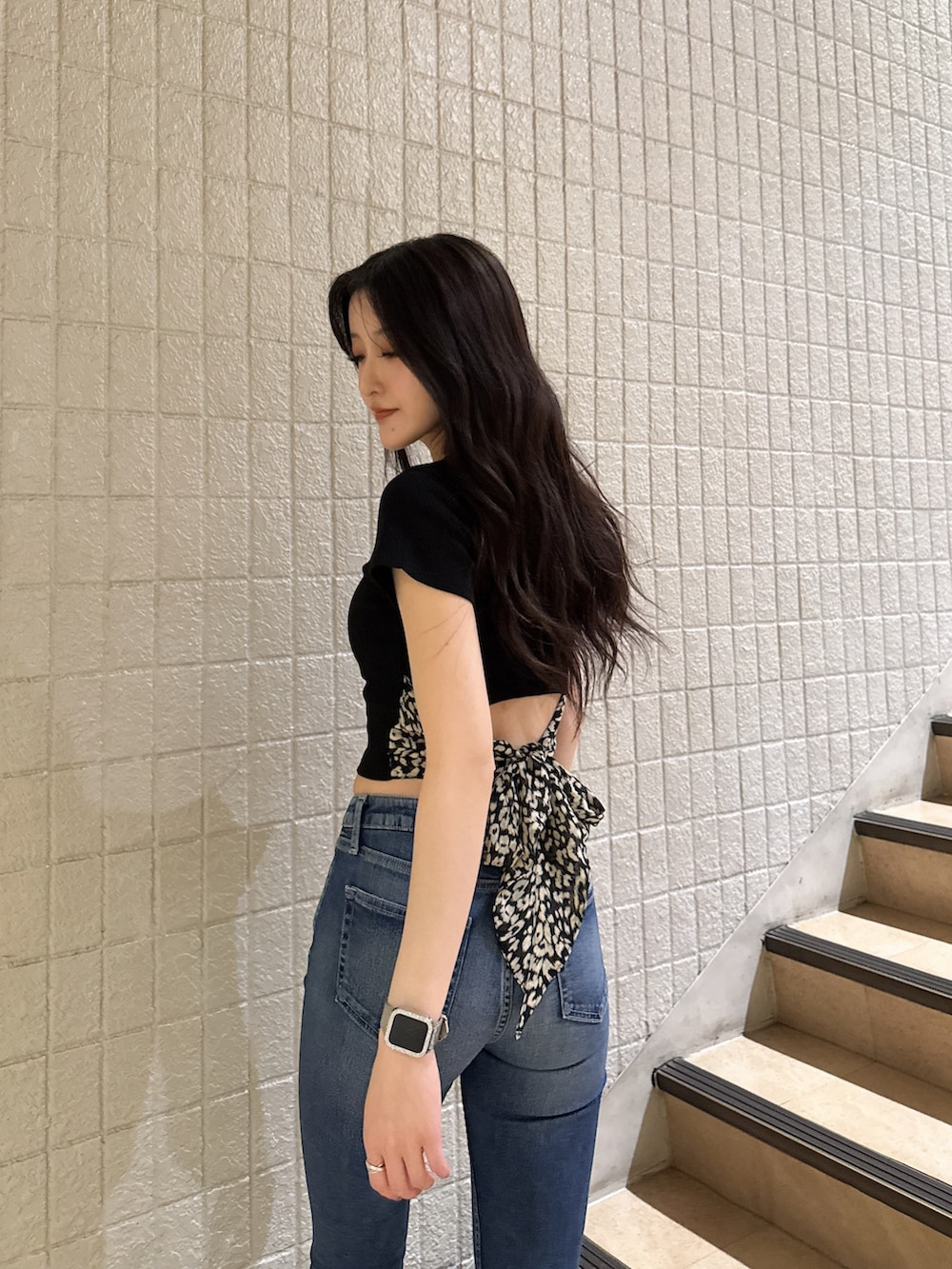 ブラック系のTシャツ/カットソー、ブルー系のデニムパンツ、ブラック系のサンダルを着用したレディースの春コーディネートの4枚目の写真