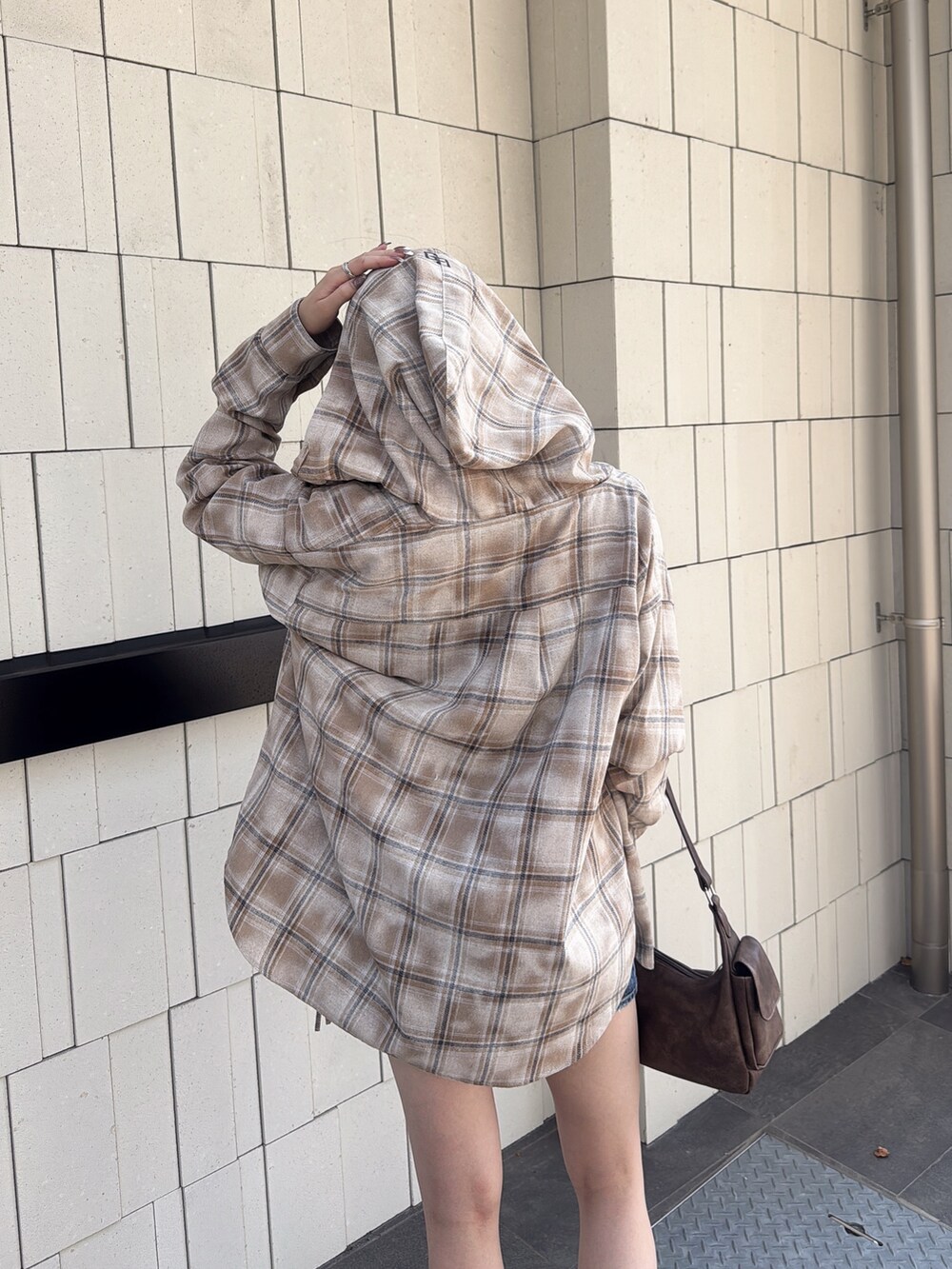 ブルー系のデニムスカート、ブラウン系のハンドバッグ、ベージュ系のシャツ/ブラウスを着用したレディースの夏コーディネートの4枚目の写真